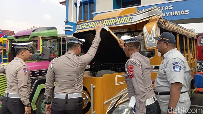 Petugas menilang rombongan odong-odong yang mengangkut lansia di kantor Satlantas Polresta Banyumas, Rabu (29/5/2024).