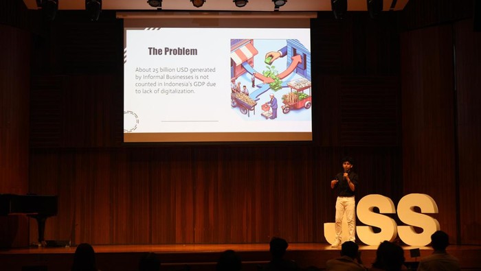 Rehan Bharwani (kiri) siswa kelas 11 Jakarta International School menjelaskan presentasi nya mengenai pentingnya inklusivitas perekonomian informal di Indonesia guna meningkatkan pemasukan negara kepada Founder of JSS Carolyn Tiemann (dua kiri) pada ajang Innovating for Impact yang diadakan oleh Jakarta Scholars Symposium di Energy Building, SCBD, Jakarta, Rabu (29/5/2024). Rehan mempusatkan presentasinya pada transformasi pembayaran secara digital yang terintegrasi dan mudah diakses secara nasional agar terjangkau oleh pemilik bisnis.