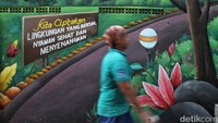 Sejumlah warga melintas di mural bertemakan Lingkungan Asri kawasan Tanjung Priok, Jakarta Utara, Kamis (30/5/2024).