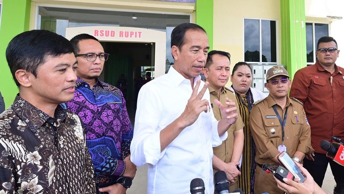 Hasan Nasbi (baju batik ungu-biru) di belakang Jokowi.