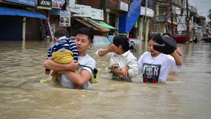 India Diterjang Banjir Bandang Imbas Topan Remal People try to pull a submerged car in the flood waters after heavy rains caused by Cyclone Remal in Imphal, Manipur, India, May 29, 2024. REUTERS/Stringer