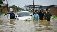 Orang-orang mencoba menarik mobil yang terendam banjir setelah hujan lebat akibat Topan Remal di Imphal, Manipur, India, Selasa (29/5/2024).