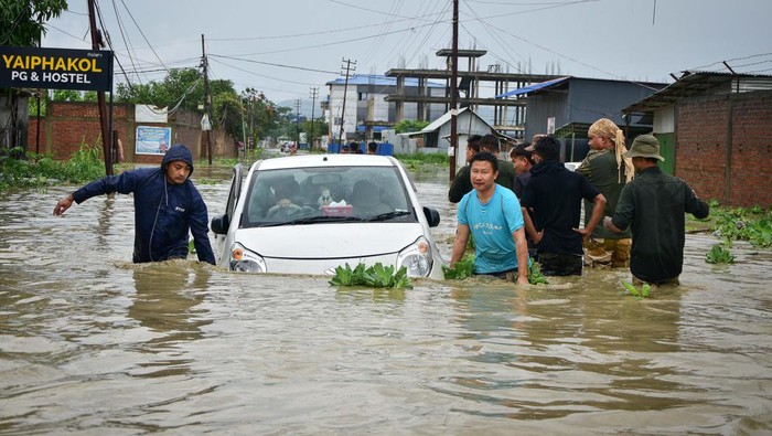 India Diterjang Banjir Bandang Imbas Topan Remal People try to pull a submerged car in the flood waters after heavy rains caused by Cyclone Remal in Imphal, Manipur, India, May 29, 2024. REUTERS/Stringer