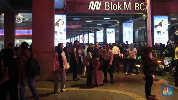 Sejumlah calon penumpangmelintas di sebelah Stasiun MRT di Blok M, Jakarta, Kamis, (30/5). Akses ke Stasiun MRT Blok M ditutup sementara setelah MRT menghentikan kegiatan operasionalnya sore ini. Penumpang pun menumpuk di sekitar Stasiun Blok M. (CNBC Indonesia/Muhammad Sabki)