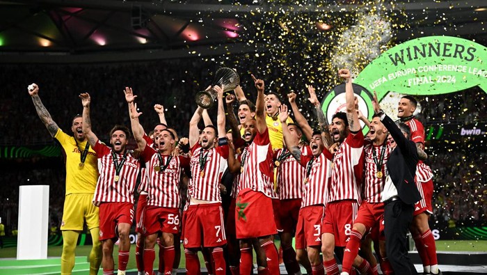 Soccer Football - Europa Conference League - Final - Olympiacos v Fiorentina - Agia Sophia Stadium, Athens, Greece - May 30, 2024 Olympiacos Kostas Fortounis lifts the trophy as he celebrates with teammates after winning the Europa Conference League REUTERS/Dylan Martinez
