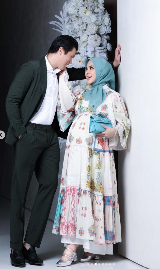 Dalam pemotretan tersebut Syahrini dan Reino tampil rapih. Reino memilih mengenakan setelan jas hitam, sementara Syahrini mengenakan dress ruffle bermotif floral dipadukan dengan sepasang sepatu silver. Foto: Instagram/@princessyahrini