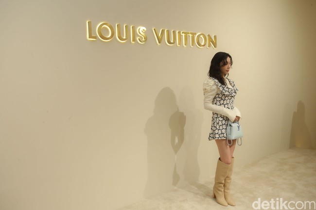 Ia kemudian memaksimalkan gayanya dengan high-knee boots kulit coklat yang tingginya sampai selutut. Tidak ketinggalan handbag LV berwarna biru pastel dari seri Capucines. (Foto: Rifkianto Nugroho/detikcom)
