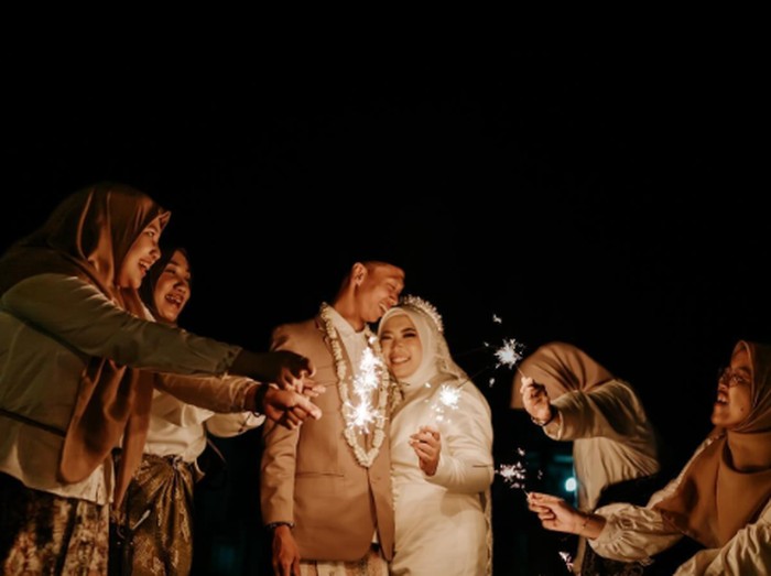 Foto pernikahan Zukha dan Fahmi yang menggelar akad nikah pada malam hari dihiasi dengan kembang api, bisa jadi inspirasi. Hasil fotonya langsung viral di TikTok dan mencuri atensi warganet