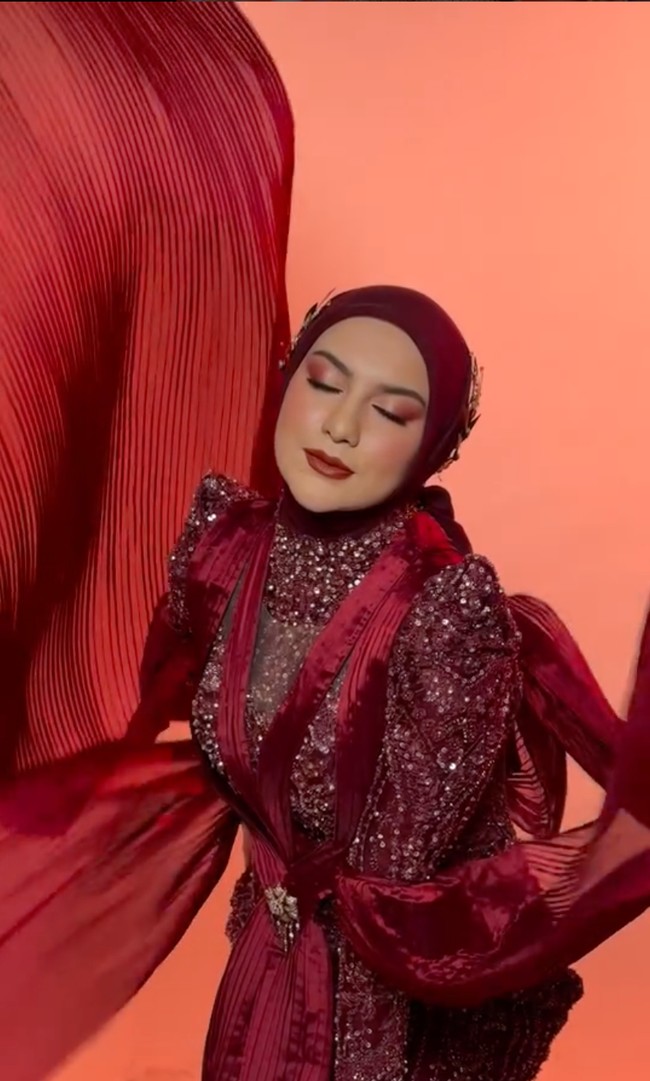 Untuk look kedua Irish tampil mengenakan gaun berwarna merah marun. Melansir Instagram perancangnya, gaun tersebut merupakan keluaran terbaru. Setiap detailnya mencerminkan wanita yang percaya diri dan pemberani, serta cantik dan anggun. Foto: Instagram/@lavienaweddinggallery