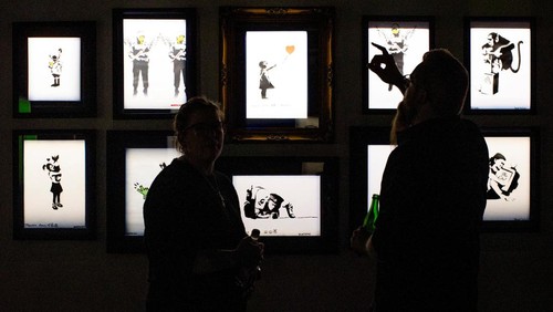 People look at some of the work by the artist Banksy during a media preview for an upcoming show in Toronto, Canada May 28, 2024. REUTERS/Carlos Osorio