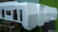 Mainan kereta ini dicat dengan warna dasar putih. Setelah itu, mainan akan dicat sesuai dengan warna asli kereta.