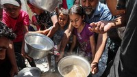 Anak-anak mengantre makanan di Khan Younis.  