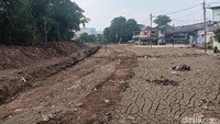 Kemudian di sisi lain terlihat ada satu alat berat berupa ekskavator berwarna biru sedang bekerja. Di dekat ekskavator itu juga terlihat ada sejumlah pekerja dan warga yang mengamati proses normalisasi Kali Ciliwung ini. Foto: Ignacio Geordy Oswaldo