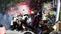 Aparat keamanan kemudian memukul mundur massa yang masih ngeyel. Massa juga nampak melakukan perlawanan dengan melempari batu dan botol kaca serta menembakkan petasan. (Foto: Rifki Afifan Pridiasto)
