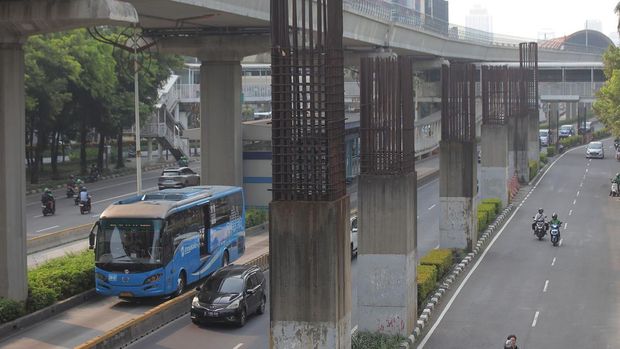 Sejumlah kendaraan melintas di antara tiang monorel yang terhenti pembangunannya di Jalan Rasuna Said,Jakarta, Jumat (31/5/2024). Pemprov DKI Jakarta akan membongkar tiang monorel yang berada di antara jalur cepat dan jalur lambat tersebut untuk perluasan jalan, dan pembongkarannya bersamaan denagan proyek pembangunan Light Rail Transit (LRT). ANTARA FOTO/Reno Esnir/Spt.