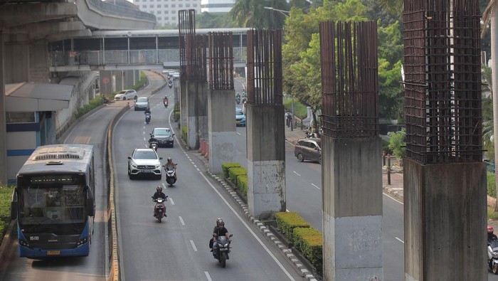 Sejumlah kendaraan melintas di antara tiang monorel yang terhenti pembangunannya di Jalan Rasuna Said,Jakarta, Jumat (31/5/2024). Pemprov DKI Jakarta akan membongkar tiang monorel yang berada di antara jalur cepat dan jalur lambat tersebut untuk perluasan jalan, dan pembongkarannya bersamaan denagan proyek pembangunan Light Rail Transit (LRT). ANTARA FOTO/Reno Esnir/Spt.