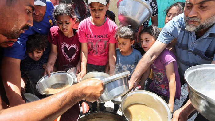 Warga Gaza Nikmati Makanan di Tengah Reruntuhan Khan Younis Palestinians cook food near houses destroyed in the Israeli military offensive, in Khan Younis in the southern Gaza Strip, May 30, 2024. REUTERS/Ramadan Abed TPX IMAGES OF THE DAY