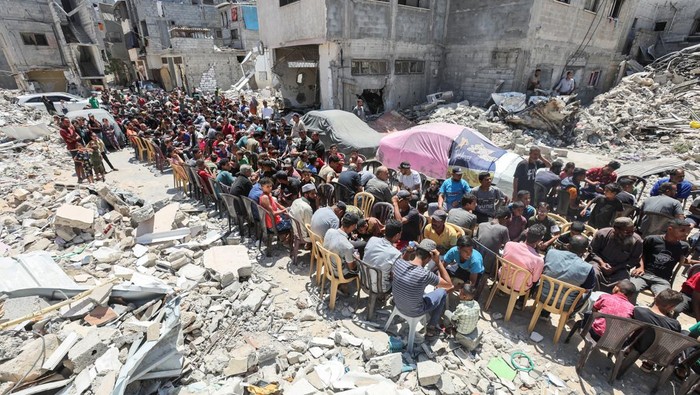 Palestinians cook food near houses destroyed in the Israeli military offensive, in Khan Younis in the southern Gaza Strip, May 30, 2024. REUTERS/Ramadan Abed TPX IMAGES OF THE DAY
