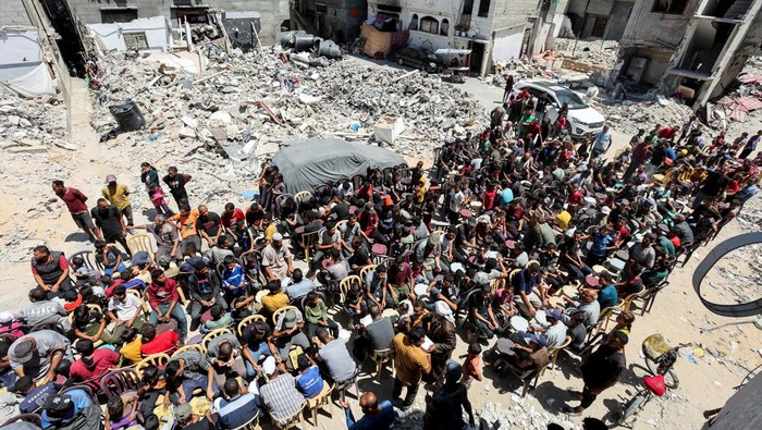 Palestinians cook food near houses destroyed in the Israeli military offensive, in Khan Younis in the southern Gaza Strip, May 30, 2024. REUTERS/Ramadan Abed     TPX IMAGES OF THE DAY