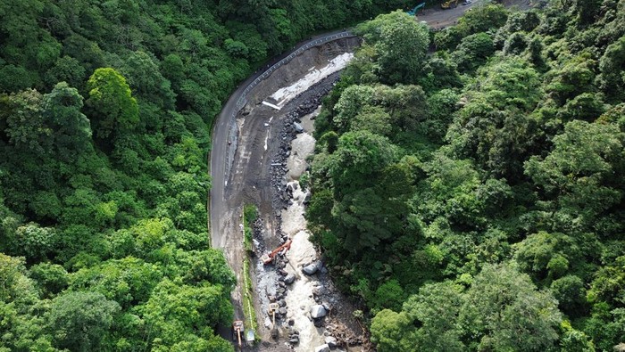 Foto udara pengerjaan perbaikan ruas jalan nasional di kawasan cagar alam Lembah Anai, Tanah Datar, Sumatera Barat, Sabtu (1/6/2024). Balai Pelaksana Jalan Nasional (BPJN) Sumbar menyebut pengerjaan perbaikan jalan nasional yang putus akibat banjir bandang itu ditargetkan selesai dan bisa dilewati kembali tanggal 21 Juli 2024 dan saat ini sedang dalam proses percepatan perbaikan dengan menurunkan 32 alat berat. ANTARA FOTO/Iggoy el Fitra/tom.