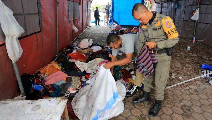 Personel Satpol PP memeriksa dan membenahi barang-barang peninggalan imigran Rohingya di tempat penampungan sementara belakang Kantor Bupati Aceh Barat, Aceh, Sabtu (1/6/2024). Menurut Komisioner Tinggi PBB untuk Pengungsi (UNHCR) wilayah Aceh Faisal Rahman dari keseluruhan 75 imigran gelap asal Bangladesh dan etnis Rohingya yang menempati penampungan sementara di Kabupaten Aceh Barat itu 11 imigran asal Bangladesh telah dipindahkan ke Rumah Detensi Imigrasi (Rudenim) Medan Kanwil Kemenkumham Provinsi Sumatera Utara sedangkan 64 imigran etnis Rohingya secara berangsur meningalkan lokasi tersebut. ANTARA FOTO/Syifa Yulinnas/tom.