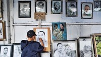 Imam sedang menyelesaikan karya lukisan di pedestrian Jalan Gubernur Suryo.