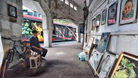 Imam sedang duduk mengahdap sejumlah karya yang ditata pada dinding di Jalan Gubernur Suryo.