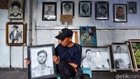 Imam menunjukan hasil karya lukis foto sejumlah tokoh yang ditata depan salah satu toko di Jalan Gubernur Suryo yang telah tutup.