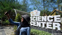 Seorang pengunjung sedang selfi bertalat belakang Kebun Raya Mangrove Surabaya.