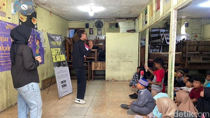 Sejumlah mahasiswa Surabaya menyosialisasikan berkendara dengan aman kepada anak-anak siswa SD.