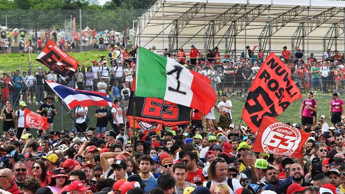 MotoGP - Italian Grand Prix - Mugello Circuit, Scarperia e San Piero, Italy - June 2, 2024 General view as spectators hold up a flag in support of Ducati Lenovo Teams Francesco Bagnaia after he wins the race REUTERS/Jennifer Lorenzini