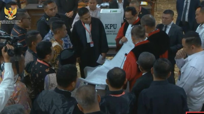 Saldi Isra mengecek ulang perolehan suara Partai Golkar selaku pemohon dan Partai Gelora sebagai pihak terkait di C hasil dan D hasil TPS 10 Desa Wakasihu, (Tangkapan layar kanal YouTube MK).