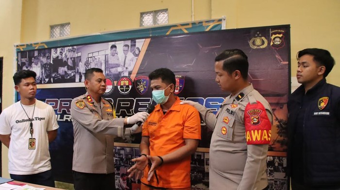 Tersangka Candra saat diamankan di kantor polisi.