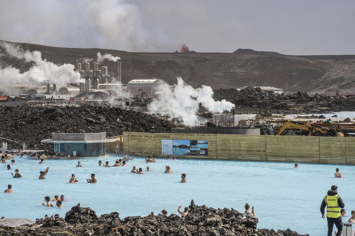 The Blue Lagoon with people bathing in it as the volcanic crater spews lava in the background in Grindavik, Iceland, Sunday, June 2, 2024. The popular Blue Lagoon geothermal spa, one of Iceland’s biggest tourist attractions in the countrys southwest, was reopened Sunday after authorities said a nearby volcano had stabilized after erupting four days earlier. (AP Photo/Marco di Marco)