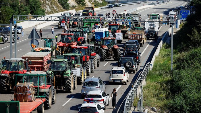 Aksi Petani Prancis dan Spanyol Blokir Perbatasan Jelang Pemilu Uni Eropa Farmers with tractors block the highway AP-7, near the border between Spain and France, as they demand better conditions ahead European elections, in Le Perthus, Spain, June 3, 2024. REUTERS/Albert Gea