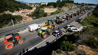 Ratusan petani mengemudikan traktor mereka ke jalan raya A7 dan memadati titik perbatasan, yang merupakan tindak lanjut dari protes serupa di seluruh Uni Eropa pada awal tahun ini. REUTERS/Albert Gea  