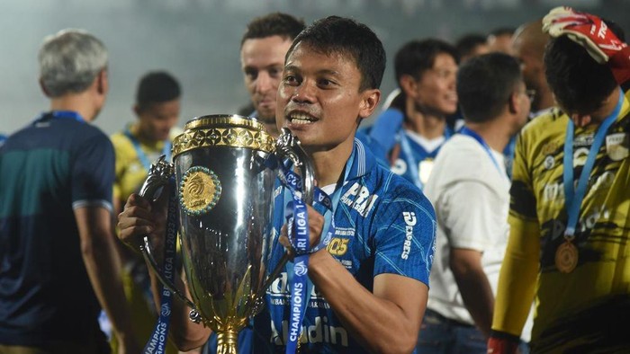 Dedi Kusnandar mengangkat trofi juara Liga 1 2023/2024.