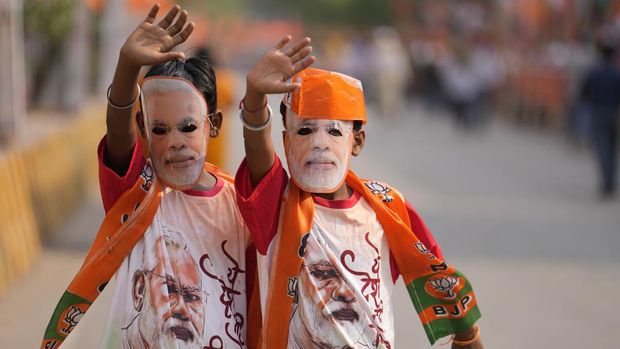 FILE- Supporters of Bharatiya Janata Party(BJP) wear masks in the likeness of Indian Prime Minister Narendra Modi during a roadshow by Modi in Varanasi, India, Monday, May 13, 2024. (AP Photo/Rajesh Kumar, File)