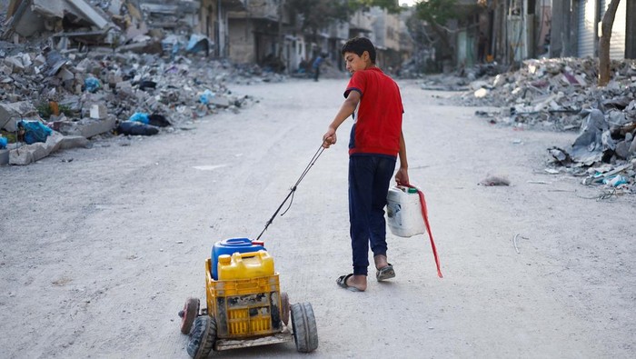 A Palestinian child stands next to water containers, amid the ongoing conflict between Israel and Hamas, in southern Gaza City, in the Gaza Strip, June 3, 2024. REUTERS/Mohammed Salem