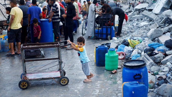A Palestinian child stands next to water containers, amid the ongoing conflict between Israel and Hamas, in southern Gaza City, in the Gaza Strip, June 3, 2024. REUTERS/Mohammed Salem