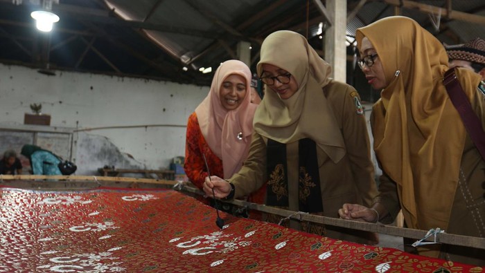 Bupati Banyuwangi Ipuk Fiestiandani (tengah) mewarnai kain batik di sentra batik Tropical Sempu, Banyuwangi, Jawa Timur, Senin (3/6/2024). Pemda setempat menciptakan berbagai program yang mendukung upaya pengembangan ekosistem batik lokal di antaranya melalui pelatihan dan festival batik sebagai upaya meningkatkan ekonomi masyarakat. ANTARA FOTO/Budi Candra Setya/Spt.