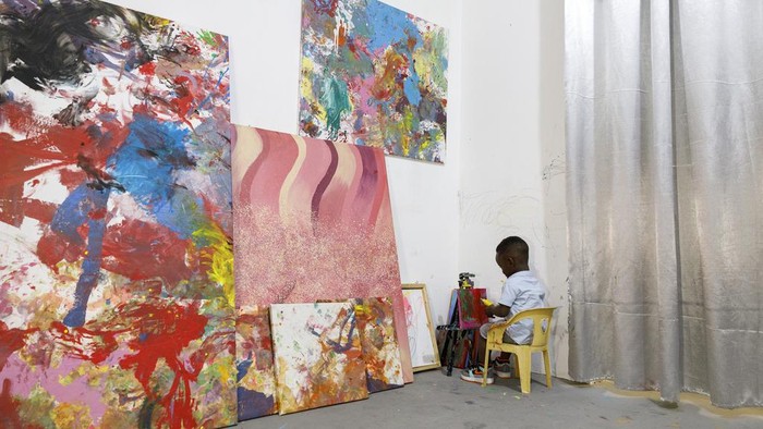 Ace-Liam Nana Sam Ankrah, who will turn two in July, paints at his mother's art gallery in Accra, Ghana, Monday, May 27, 2024. Ankrah has set the record as the world's youngest male artist. His mother, Chantelle Kukua Eghan, says it all started by accident when her son, who at the time was 6 months old, discovered her paints. (AP Photo/Misper Apawu)