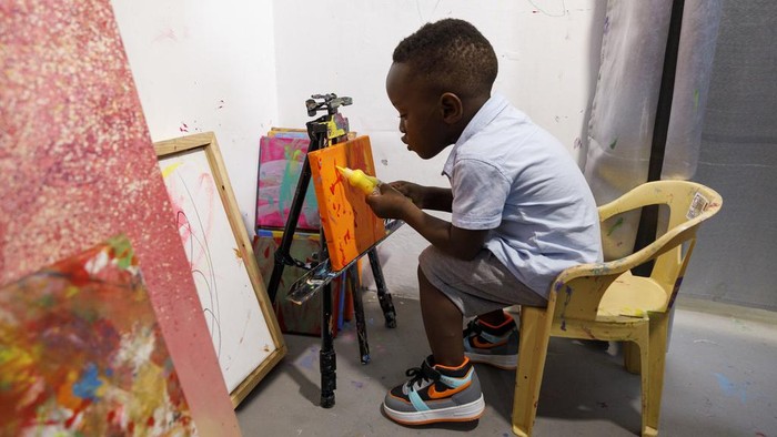 Ace-Liam Nana Sam Ankrah, who will turn two in July, paints at his mother's art gallery in Accra, Ghana, Monday, May 27, 2024. Ankrah has set the record as the world's youngest male artist. His mother, Chantelle Kukua Eghan, says it all started by accident when her son, who at the time was 6 months old, discovered her paints. (AP Photo/Misper Apawu)