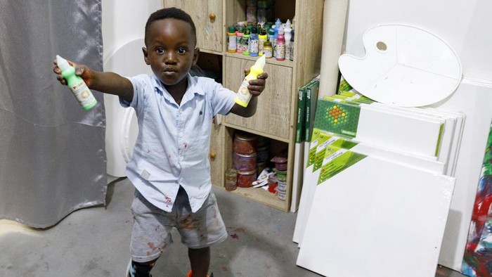 Ace-Liam Nana Sam Ankrah, who will turn two in July, paints at his mother's art gallery in Accra, Ghana, Monday, May 27, 2024. Ankrah has set the record as the world's youngest male artist. His mother, Chantelle Kukua Eghan, says it all started by accident when her son, who at the time was 6 months old, discovered her paints. (AP Photo/Misper Apawu)