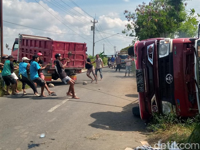 Proses evakuasi truk muatan batu terguling yang terguling hingga masuk sungai di jalan Janti-Tegalgondo, Desa Sidoharjo, Kecamatan Polanharjo, Kabupaten Klaten, Selasa (4/6/2024) siang.