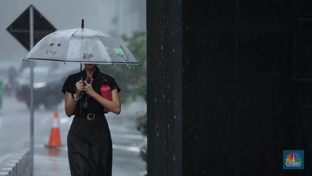 Sejumlah pengendara berteduh saat hujan deras dan angin kencang di kawasan Sudirman, Jakarta, Selasa (4/6/2024). (CNBC Indonesia/Tri Susilo)