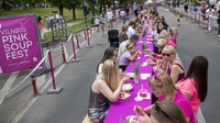 Orang-orang menyantap sup merah muda di meja sepanjang 362 meter saat perayaan Festival Sup Merah Muda di Vilnius, Lituania.  