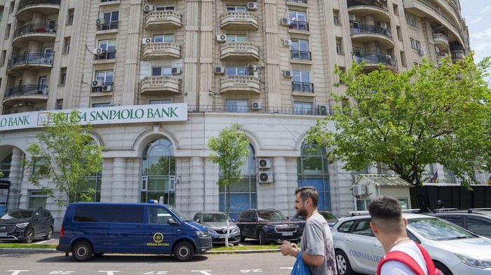 Members of a special unit of the Romanian gendarmerie stand next to a diplomatic vehicle outside the apartment block in which the Israeli embassy is located in Bucharest, Romania, Monday, June 3, 2024. A foreign citizen was detained in Romania's capital on Monday after allegedly attacking the entrance of the Israeli Embassy with a Molotov cocktail, causing a small fire but no casualties, local media and police reported. (AP Photo/Vadim Ghirda)