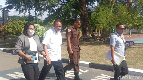 Jonas Salean (tengah baju putih) saat memasuki Kejati NTT untuk diperiksa sebagai saksi kasus korupsi pengalihan aset Pemkab Kupang. (Yufengki Bria/detikBali)