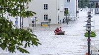 Sebuah sekoci menavigasi perairan banjir Danube di kota tua Passau, Jerman, Selasa (4/6/2024). Setelah hujan deras, banyak tempat di Bavaria terus terendam banjir. AP/Armin Weigel